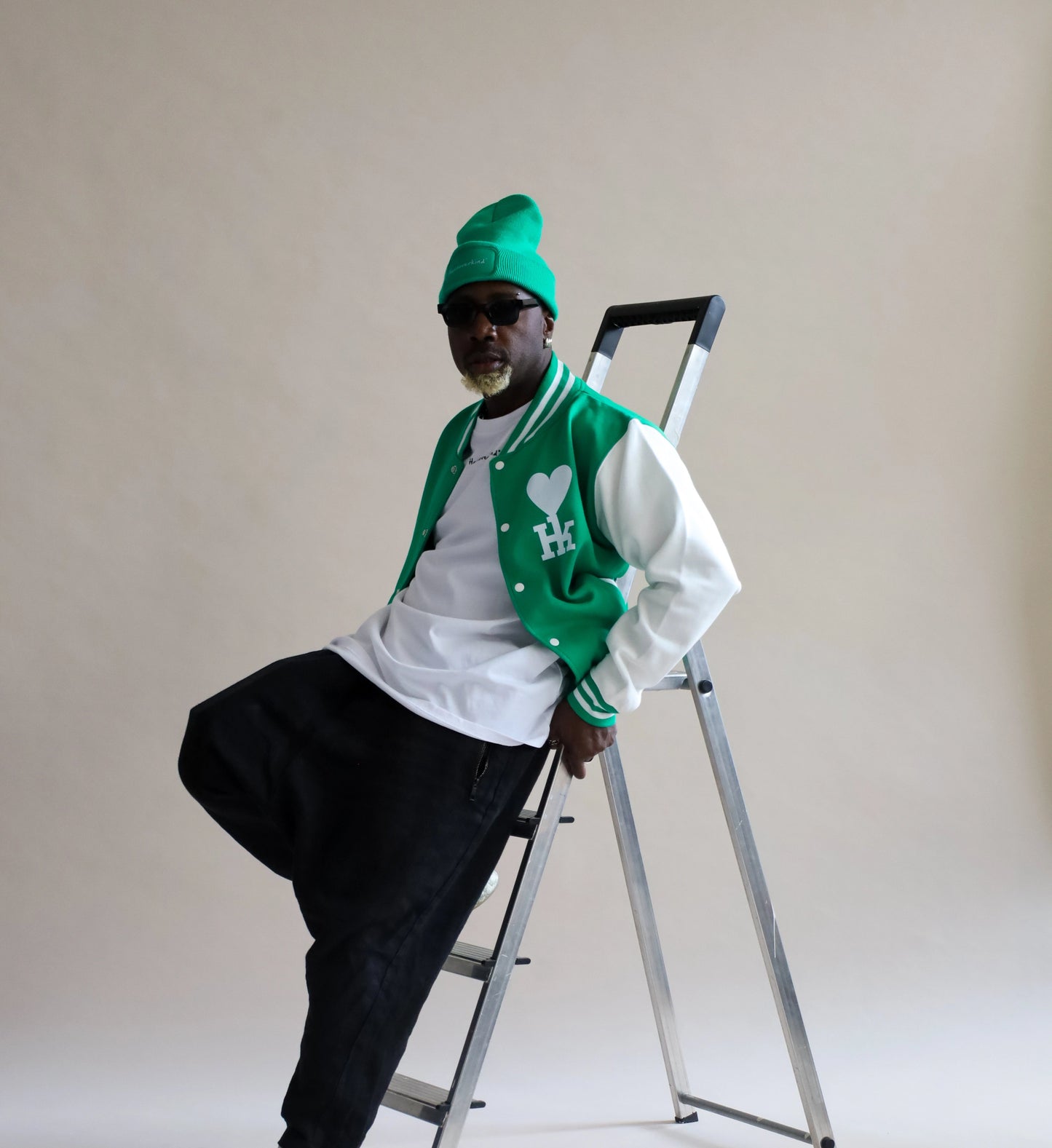 Mann trägt eine grüne trendige Collegejacke